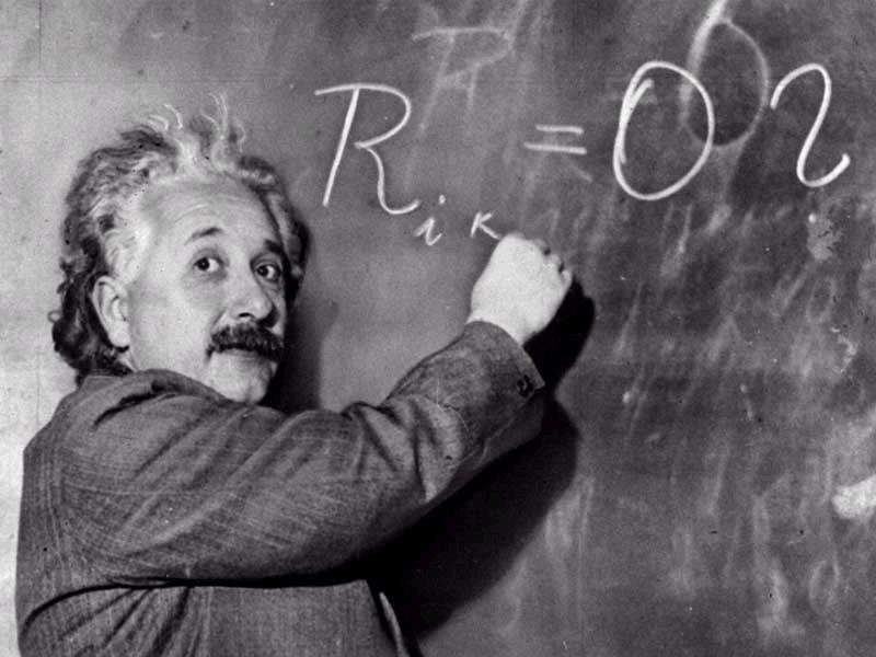 albert einstein writing on a blackboard
