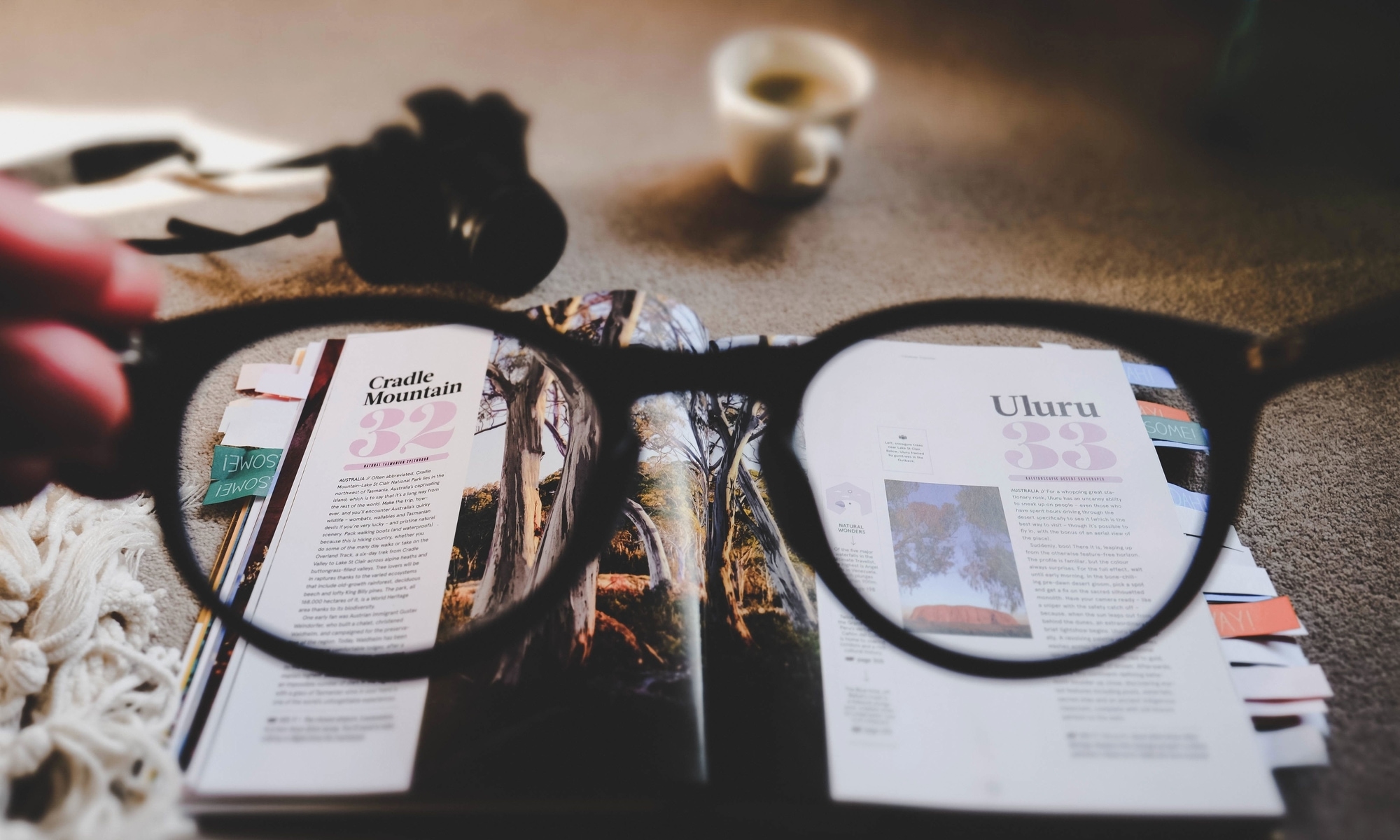 a pair of spectacles, highlighting two pages of a travel book