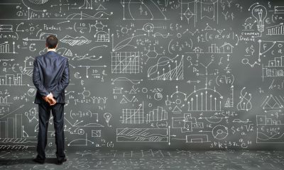 a man contemplating a blackboard of symbols