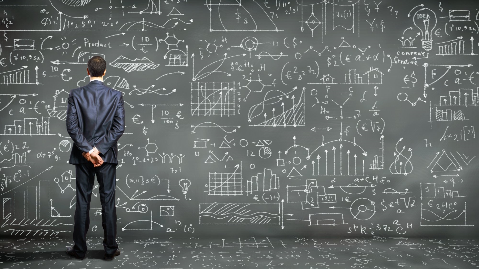 a man contemplating a blackboard of symbols
